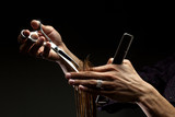 Fototapeta  - A close-up of hairdresser's hands cutting hair
