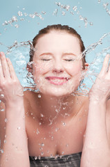 Portrait of beautiful emotional woman washing face