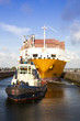 Container ship with tug boat in lock