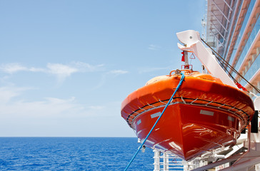 Poster - Orange Lifeboat Hanging From Harness Over Deep Blue Sea