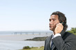 © policas - Young happy businessman calling on mobile phone, outdoor