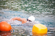 Schwimmer beim Triathlon Wettkampf im Wasser mit Schwimmbrille und Schwimmhaube