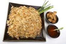 Pancit On A Ceramic Dish With Egg Rolls And Sweet And Sour Sauce