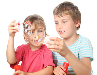 Wall Mural - little boy and girl sitting, smiling and blowing bubbles