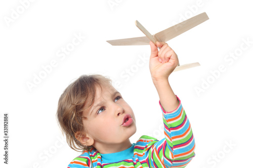 Fotografie, Obraz little girl in striped shirt playing with wooden toy plane