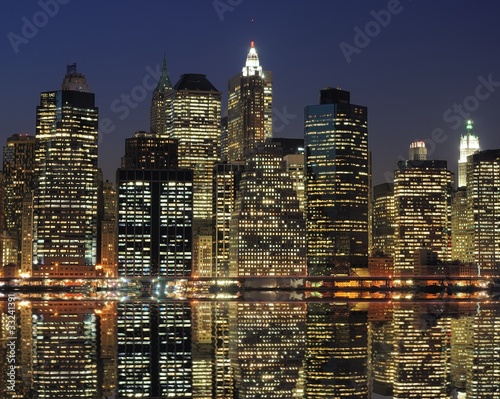 Board z aluminiowym obramowaniem Niższe manhattan w nocy z odbicia rzeki