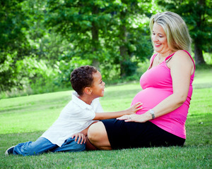 Portrait of mixed race mother and son with pregnant mom