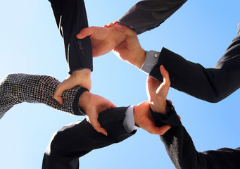 Six business persons holding their hands in form of a star