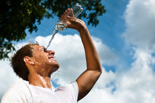 sportsman throwing water over his head for refreshment