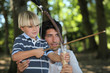 a man and a little boy doing archery in the forest