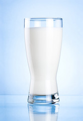 Wall Mural - Glass of milk on blue background