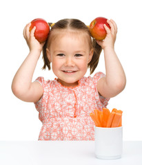 Wall Mural - Cute little girl eats carrot and apples