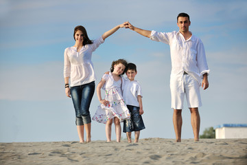 family on beach showing home sign