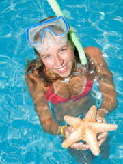 Wall Mural - Snorkel girl with starfish in blue water