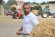 a farmer taking straw with a fork