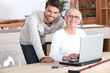 © auremar - Young man helping senior woman with a laptop compute