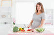 © WavebreakmediaMicro - Beautiful pregnant woman posing while cooking vegetables