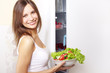 © Anton Maltsev - Young woman with healthy salad. background refrigerator