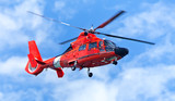 Fototapeta  - Red rescue helicopter moving in blue sky