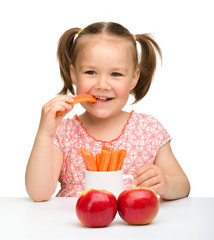 Wall Mural - Cute little girl eats carrot and apples