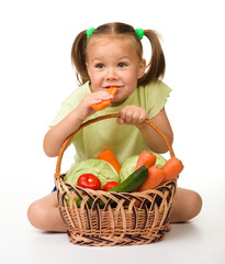 Wall Mural - Cute little girl eats carrot