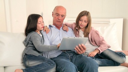 Wall Mural - Grandfather with kids using electronic tablet