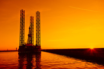 Wall Mural - Oil rig at sunset background.