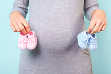 Pregnant Woman Holding Baby Booties
