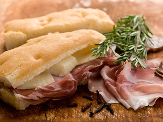 focaccia with speck and cheese over cutting board