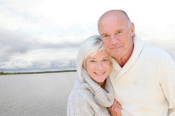 Canvas Print - Portrait of happy senior couple standing by a lake