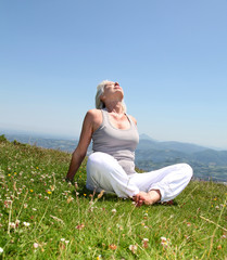 Wall Mural - Senior woman doing stretching exercises in countryside