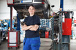 Smiling young female mechanic in garage