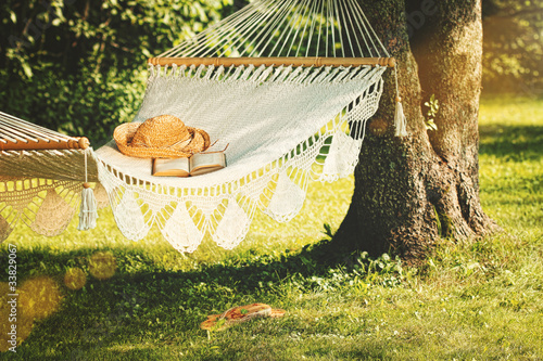 View of hammock and book on a summer day Poster Mural XXL