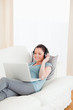 © WavebreakmediaMicro - Attractive female with headphones relaxing on her laptop while l