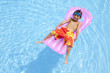 浮き輪でプールに浮かぶ水着姿の男の子