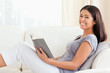 © WavebreakmediaMicro - young woman reading a book sitting on sofa smiles into camera