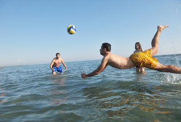 Wall Mural - young people group have fun and play beach volleyball