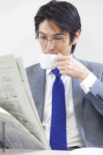 新聞を読みながらコーヒーを飲むビジネスマン Stock Photo Adobe Stock