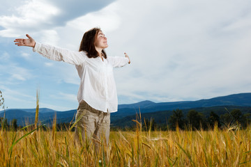 Girl holding arms up against blue sky