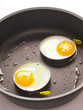 close up of fried eggs in a pan