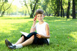 © Sergey Nivens - Portrait of a boy with a book in the park
