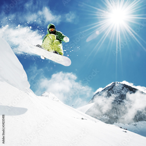 Nowoczesny obraz na płótnie Snowboarder at jump inhigh mountains