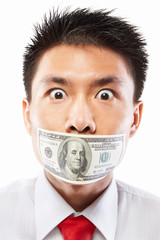 Bribe concept, mouth sealed with dollar bill