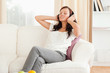 © WavebreakmediaMicro - Cute woman relaxing on a sofa listening to music