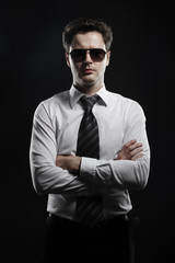 Portrait of a young businessman in sunglasses and white shirt