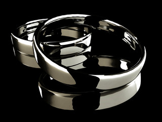 Platinum wedding rings on black background