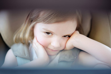 Wall Mural - Adorable little girl sitting in a car seat