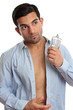 Man with bottle of cologne while dressing