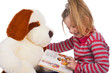 girl reading a book with a soft toy