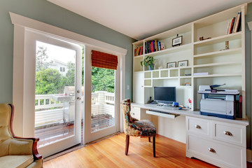 Home office with green walls and white shelves